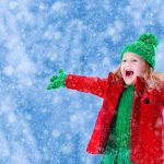 little girl playing in a snowfall