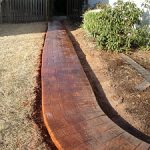 Red brickwork through grass to back wooden gate