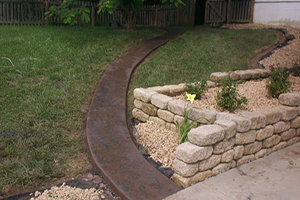 Black stone path leading to wooden gate from driveway